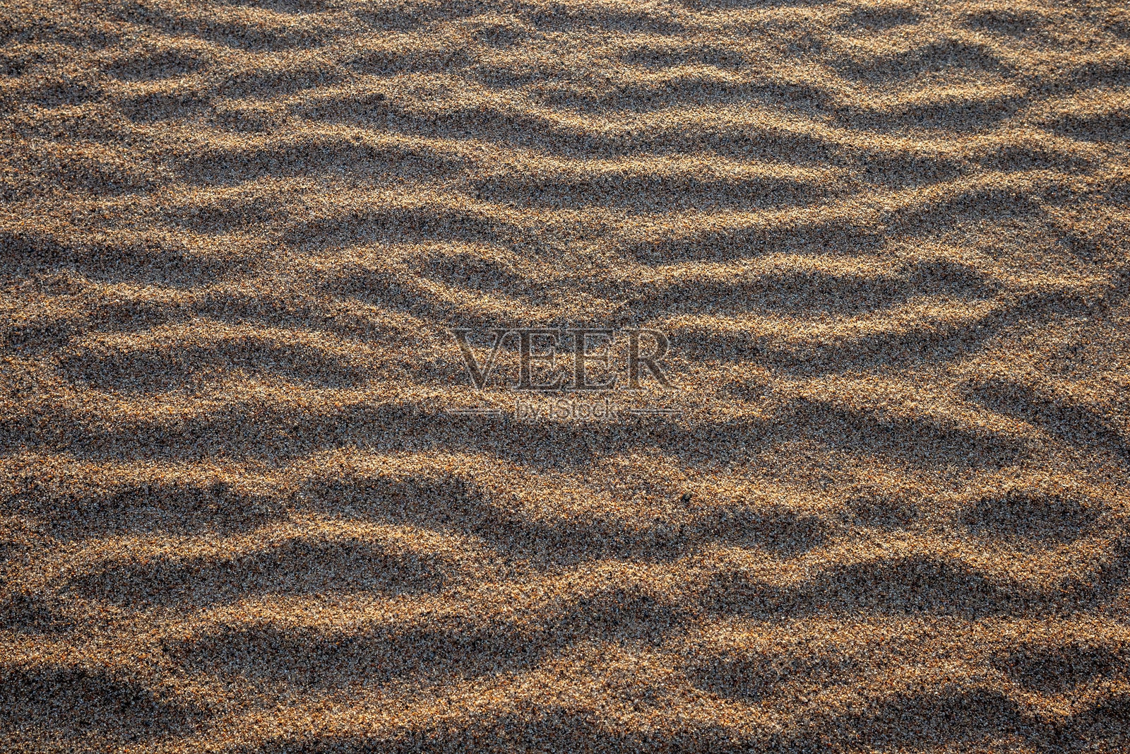 海滩上的沙子因风吹而形成的波浪纹理背景照片摄影图片