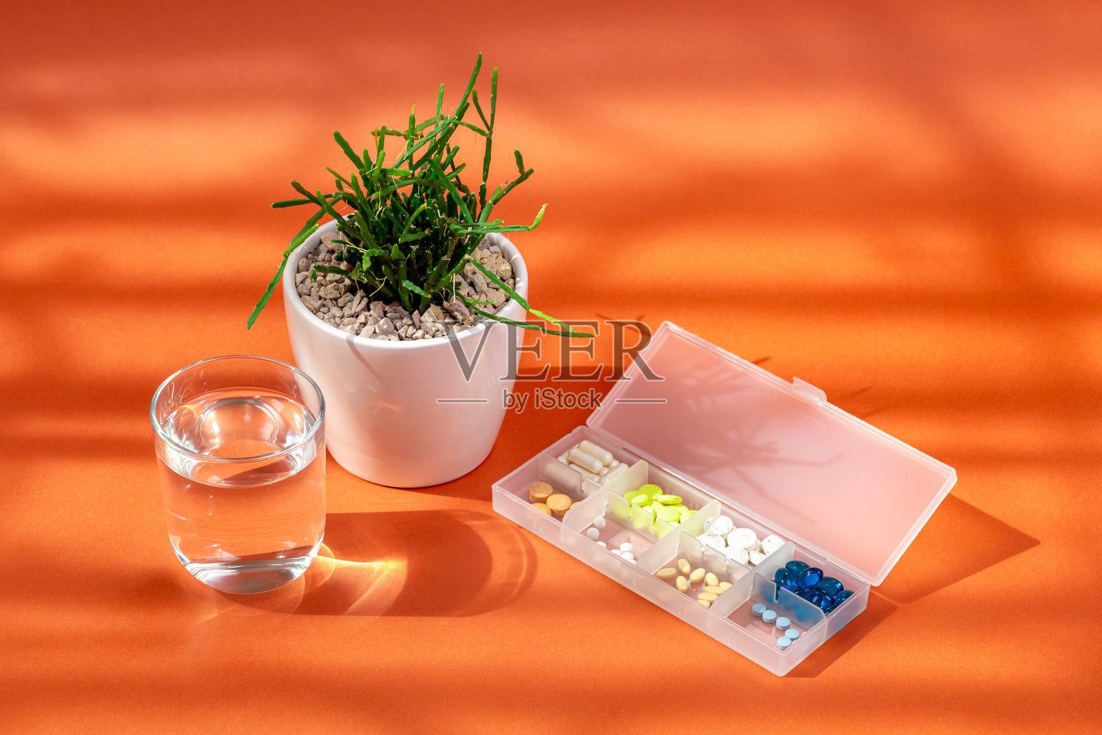营养补充剂、维生素和矿物质，阳光下的橘色背景室内植物照片摄影图片
