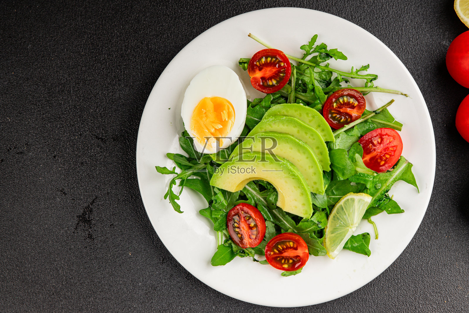 牛油果芝麻菜沙拉，配有鸡蛋、番茄、混合蔬菜，美味的异国情调美食，桌面乡村风格，俯视角度，留有复制空间，适合生酮和旧石器饮食的素食食品照片摄影图片