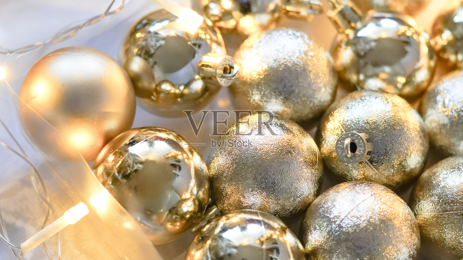 银色圣诞装饰球在柔和的冬日暖光下轻轻闪耀，营造宁静祥和的氛围。照片摄影图片