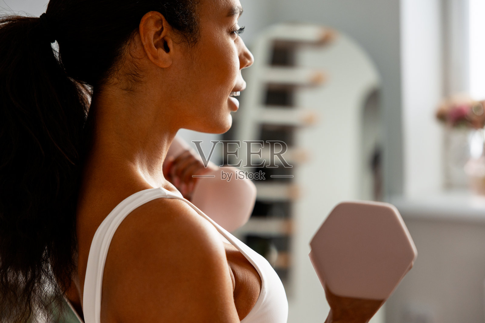 女性在家使用哑铃进行力量训练照片摄影图片