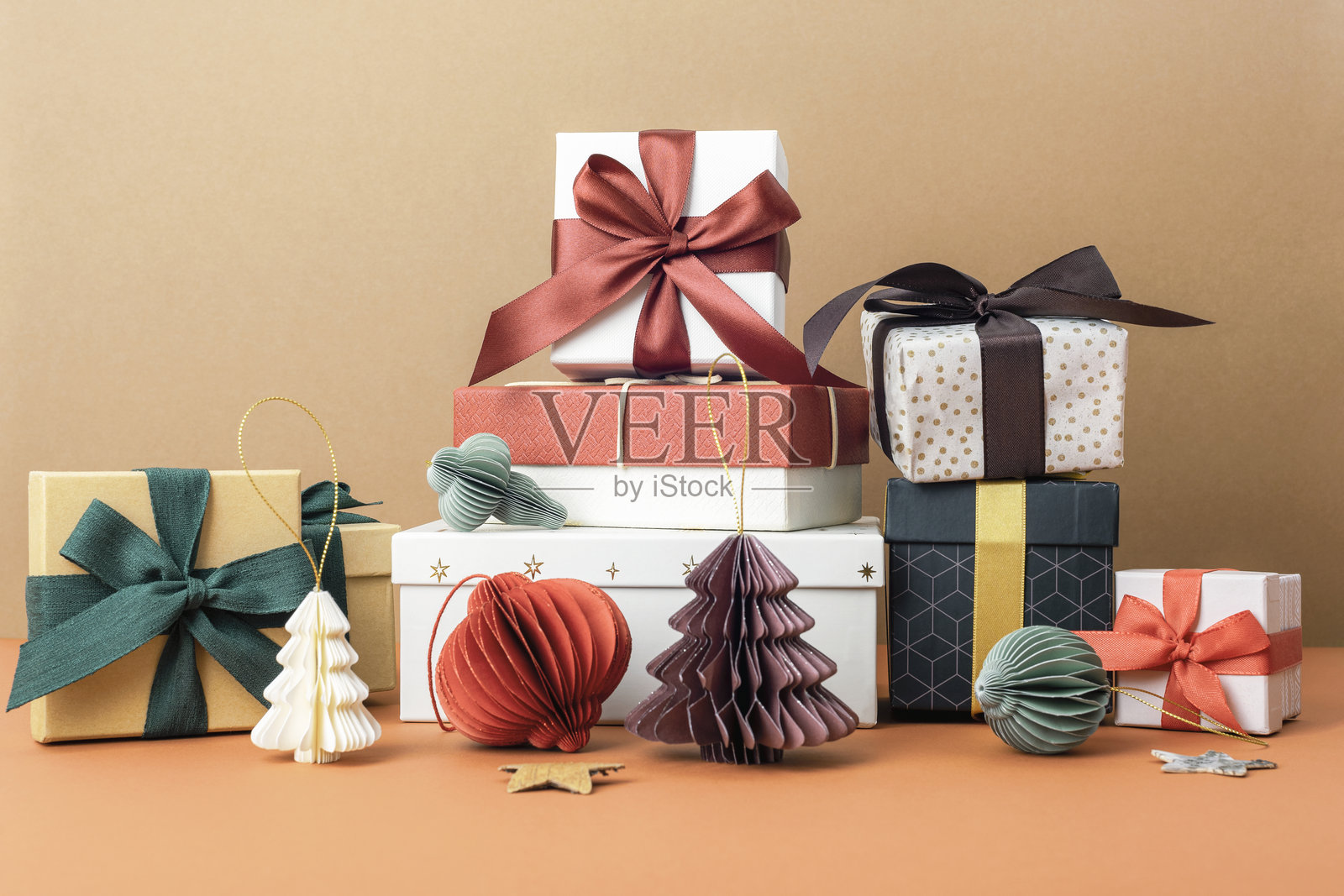 米色背景上的圣诞节包装礼物和节日装饰，有白色、红色和黑色礼品盒和蝴蝶结。节日庆典概念照片摄影图片