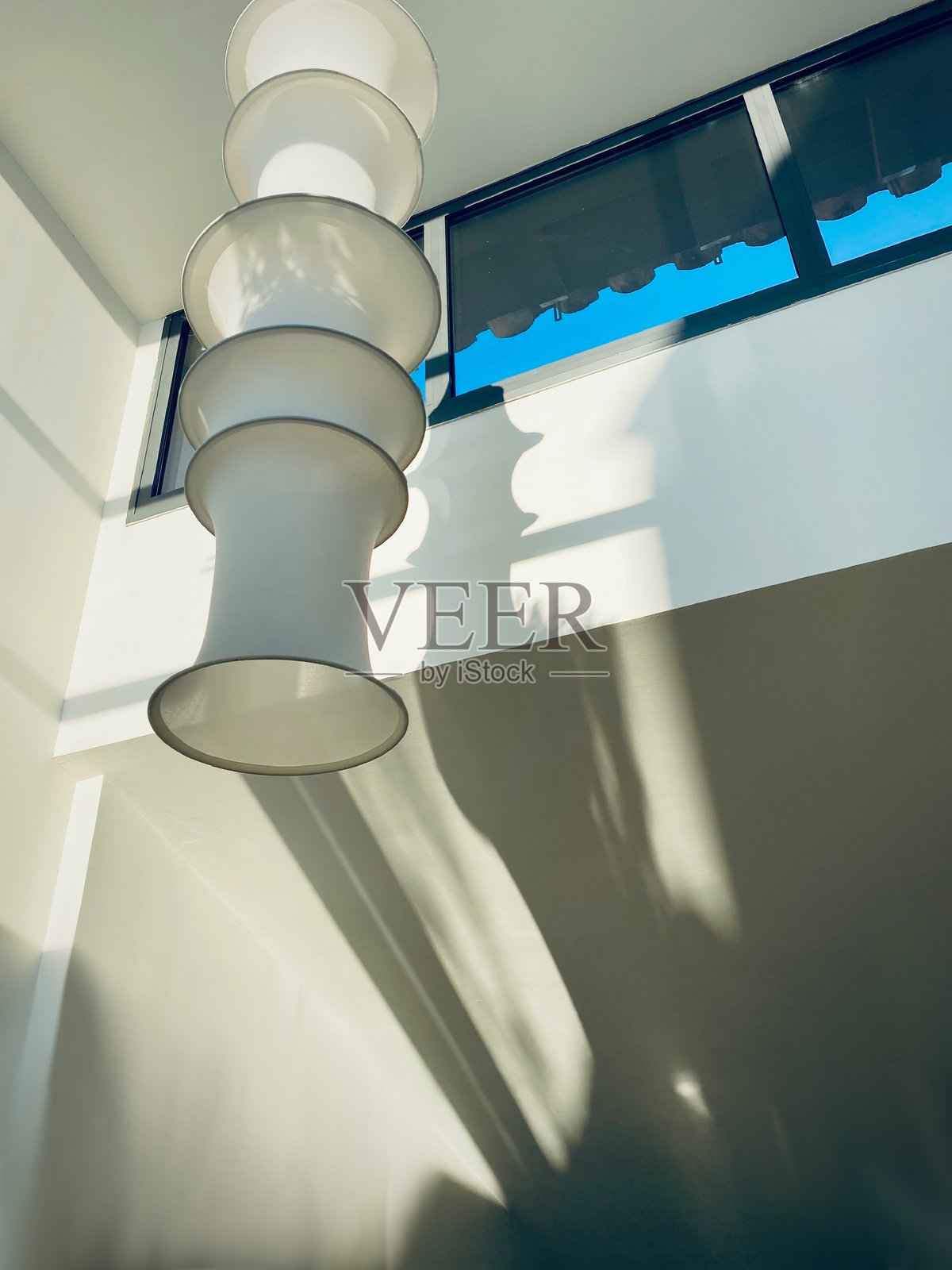 高天花板房间内的长吊灯。照片摄影图片