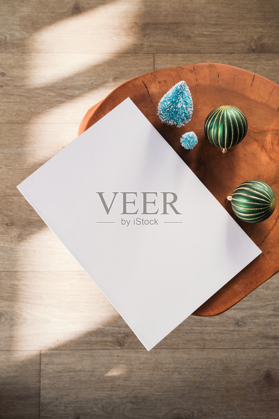 桌上摆放着带有圣诞和新年装饰的空白杂志模型，并投下阴影照片摄影图片