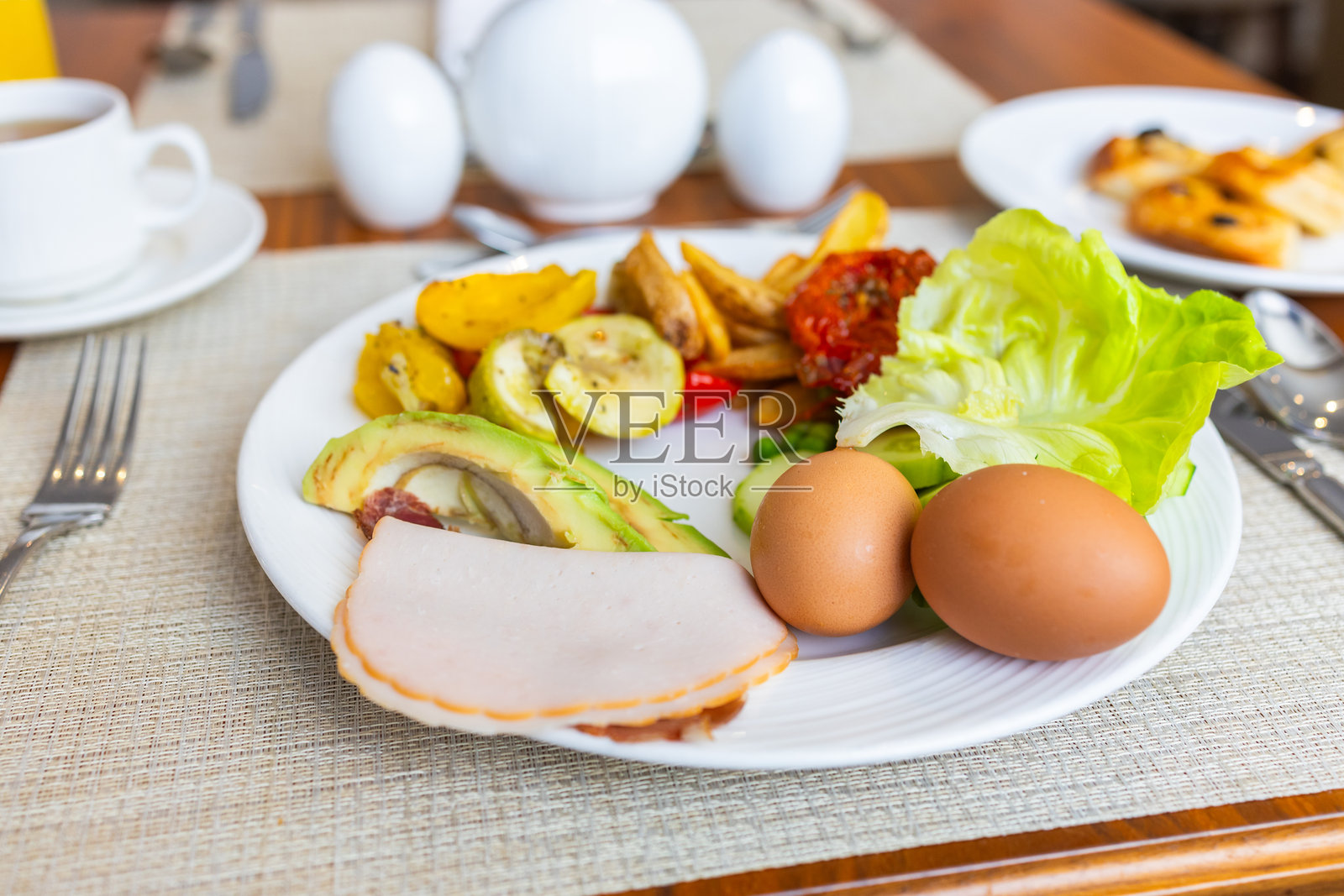 白色盘子里的健康早餐，包含蔬菜、鸡蛋和冷切肉。营养餐、新鲜食材和均衡饮食的概念。照片摄影图片