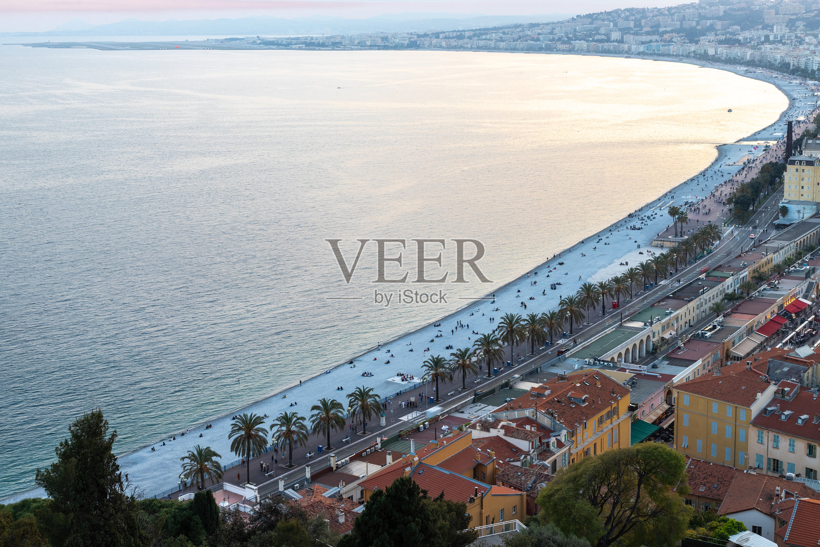 初春时分，从老城区“老维也”城堡眺望，地中海宁静，尼斯海岸沐浴在金色时光的日落余晖中。照片摄影图片