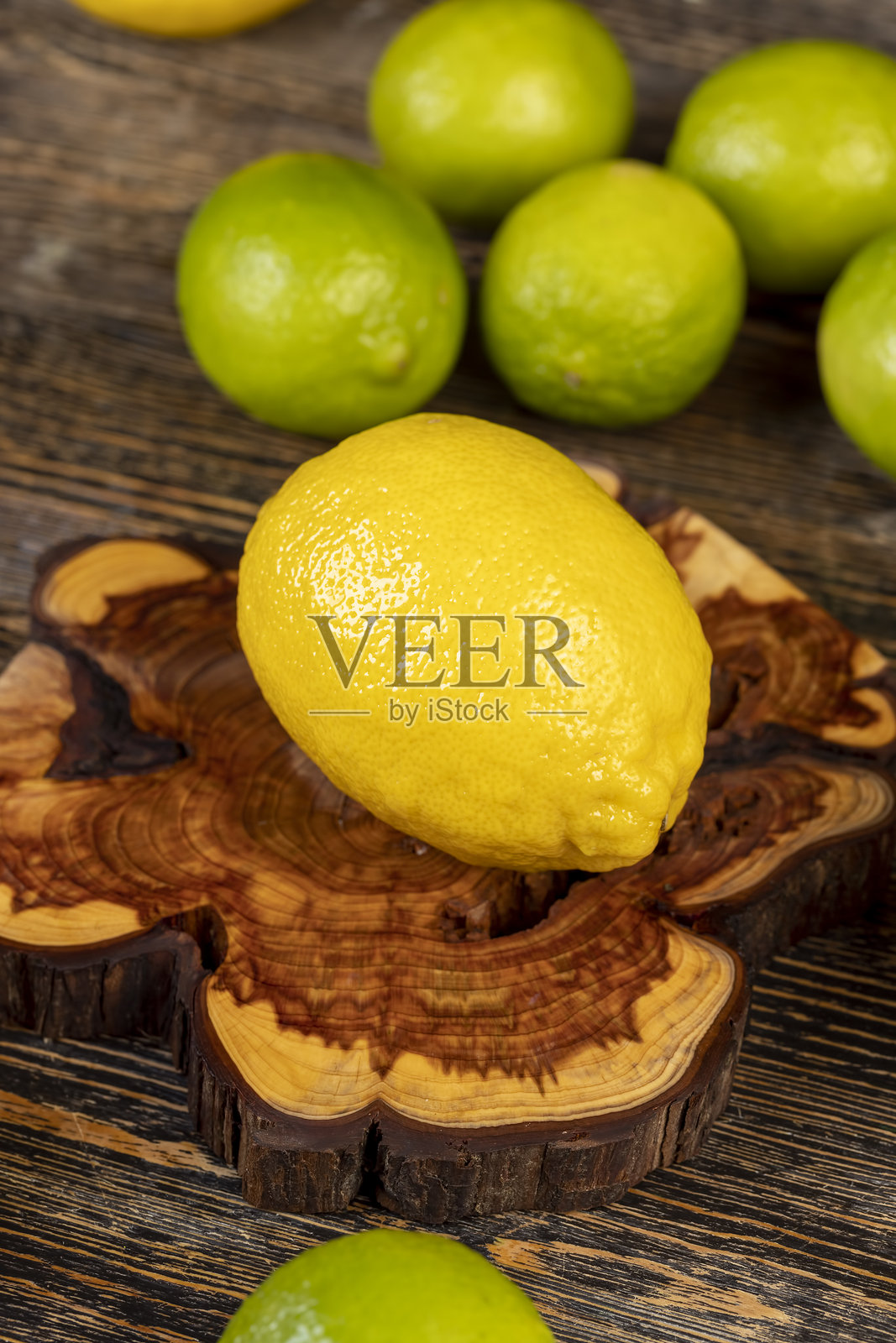 桌子上放着黄色的柠檬和绿色的青柠，成熟的柑橘类水果柠檬和青柠放在木桌上照片摄影图片