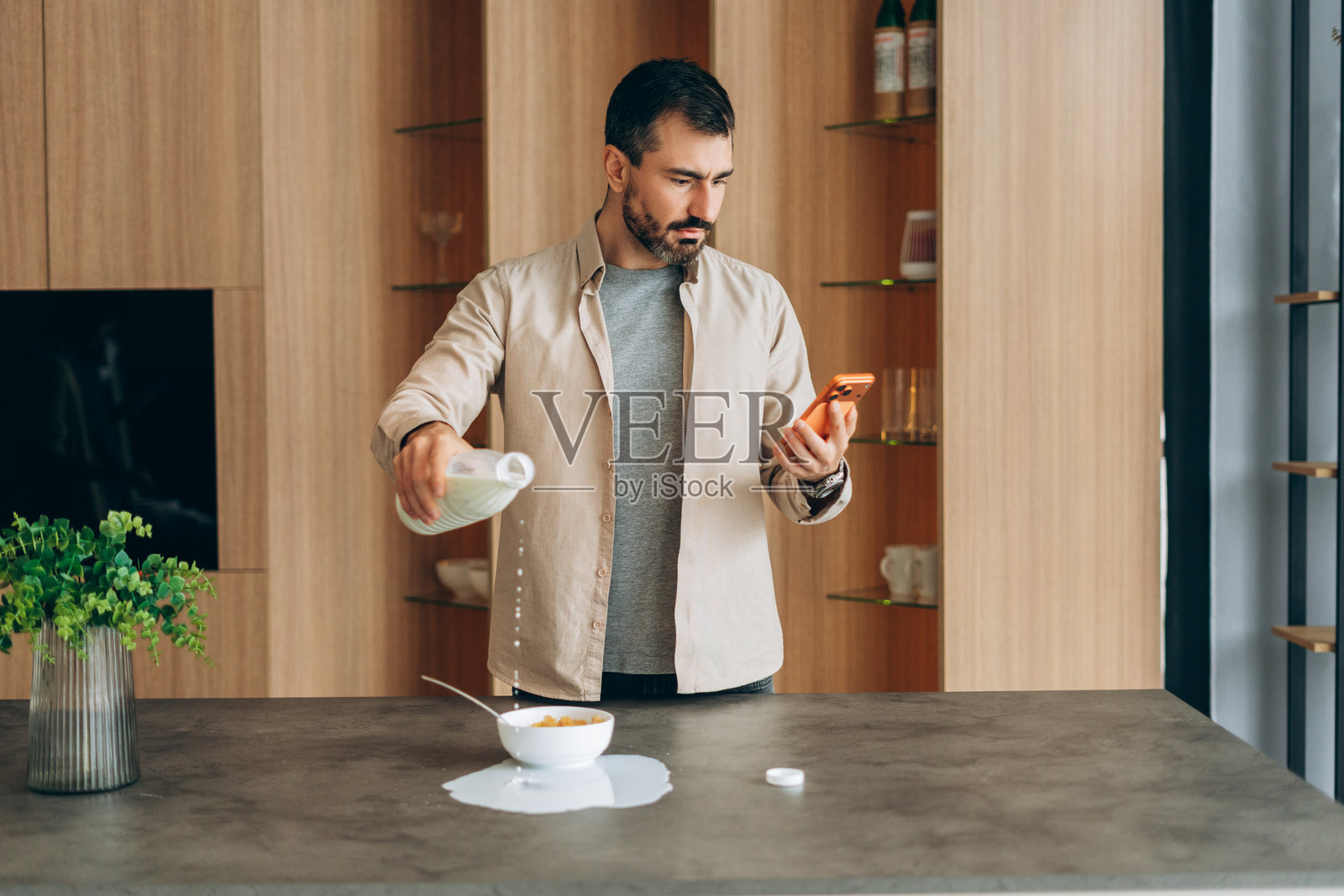 男子因看手机分心而打翻了牛奶照片摄影图片