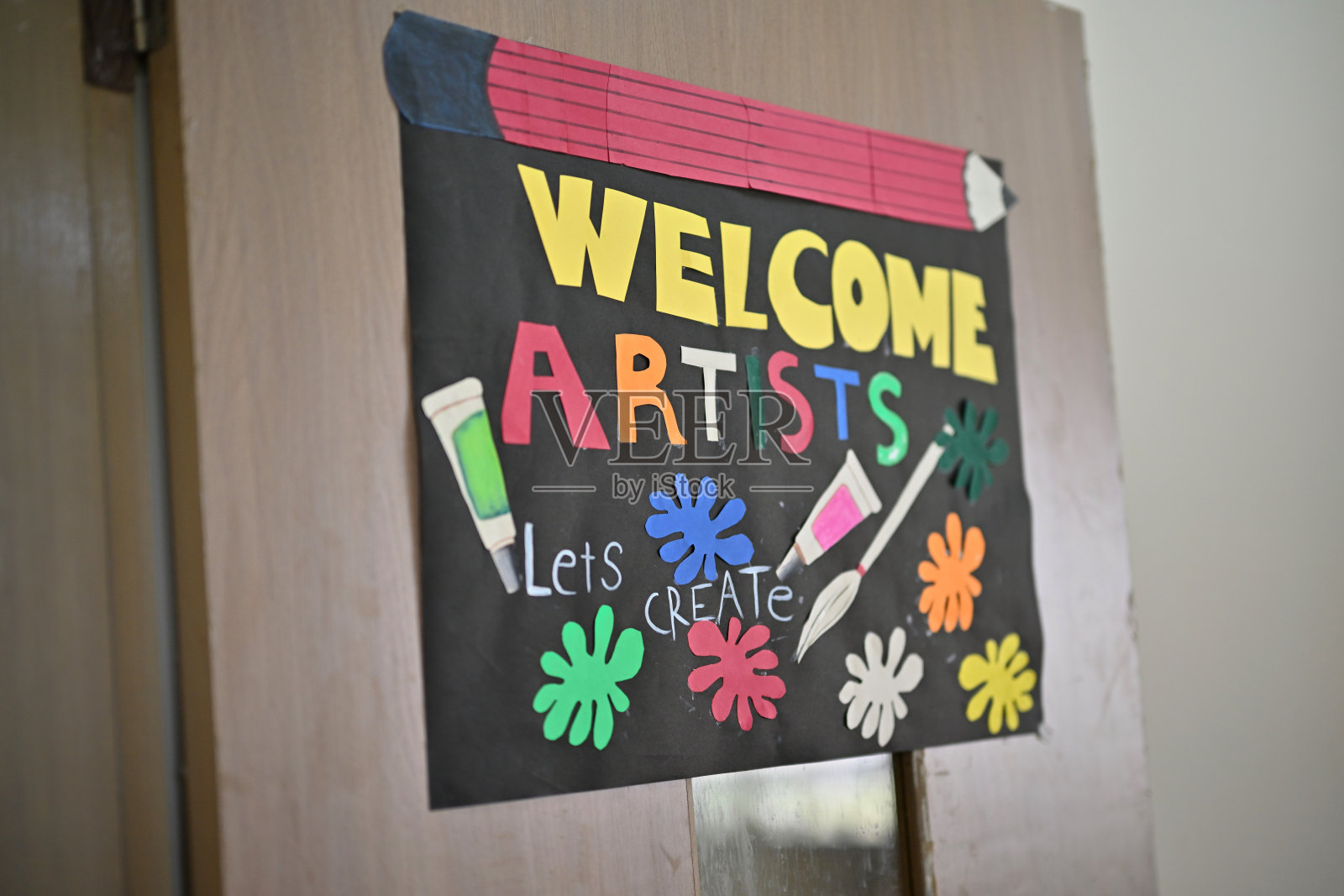 手工制作的标牌挂在艺术教室的门上，上面写着“欢迎艺术家——让我们一起创作！”照片摄影图片