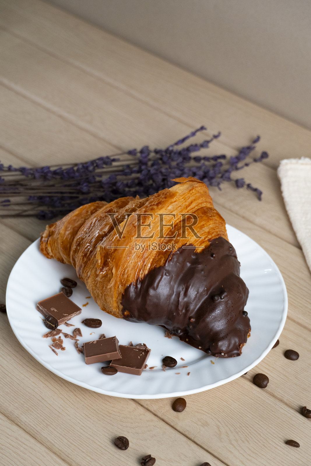 蘸有巧克力的羊角面包，配以咖啡豆和薰衣草照片摄影图片