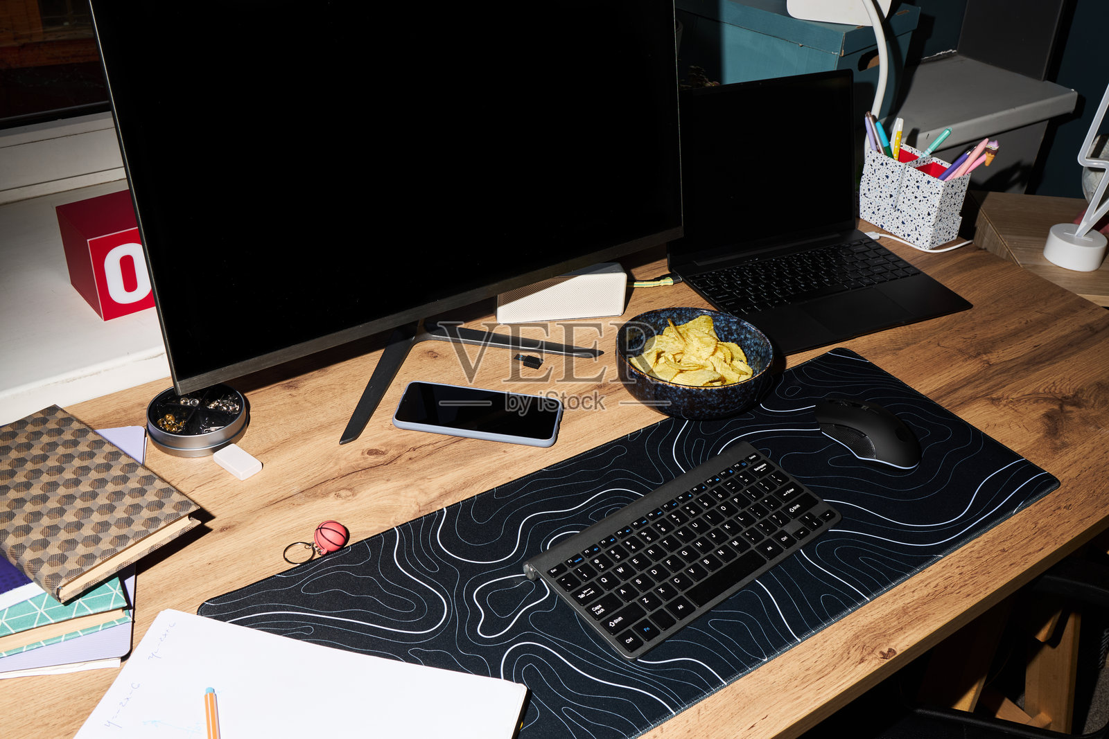 现代家庭办公室书桌，配有电脑显示器、笔记本电脑和零食碗照片摄影图片