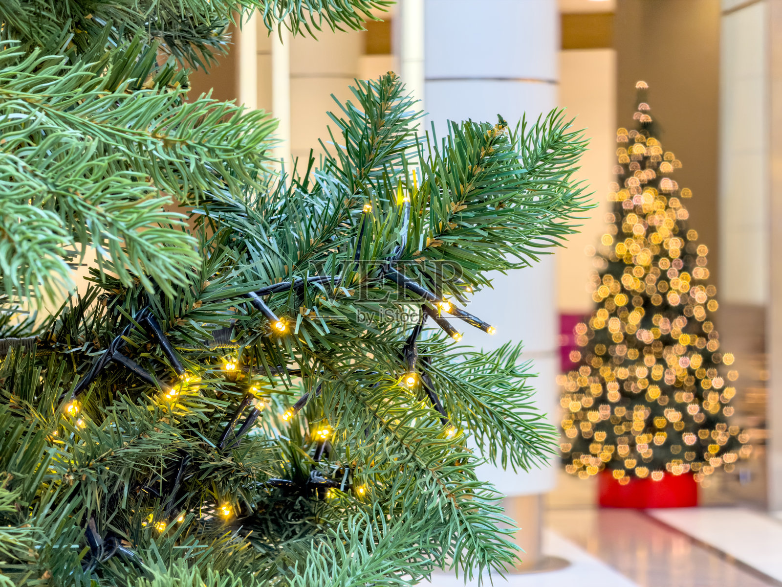 现代大堂内圣诞树灯的特写，背景是温暖喜庆的散景，气氛明亮照片摄影图片