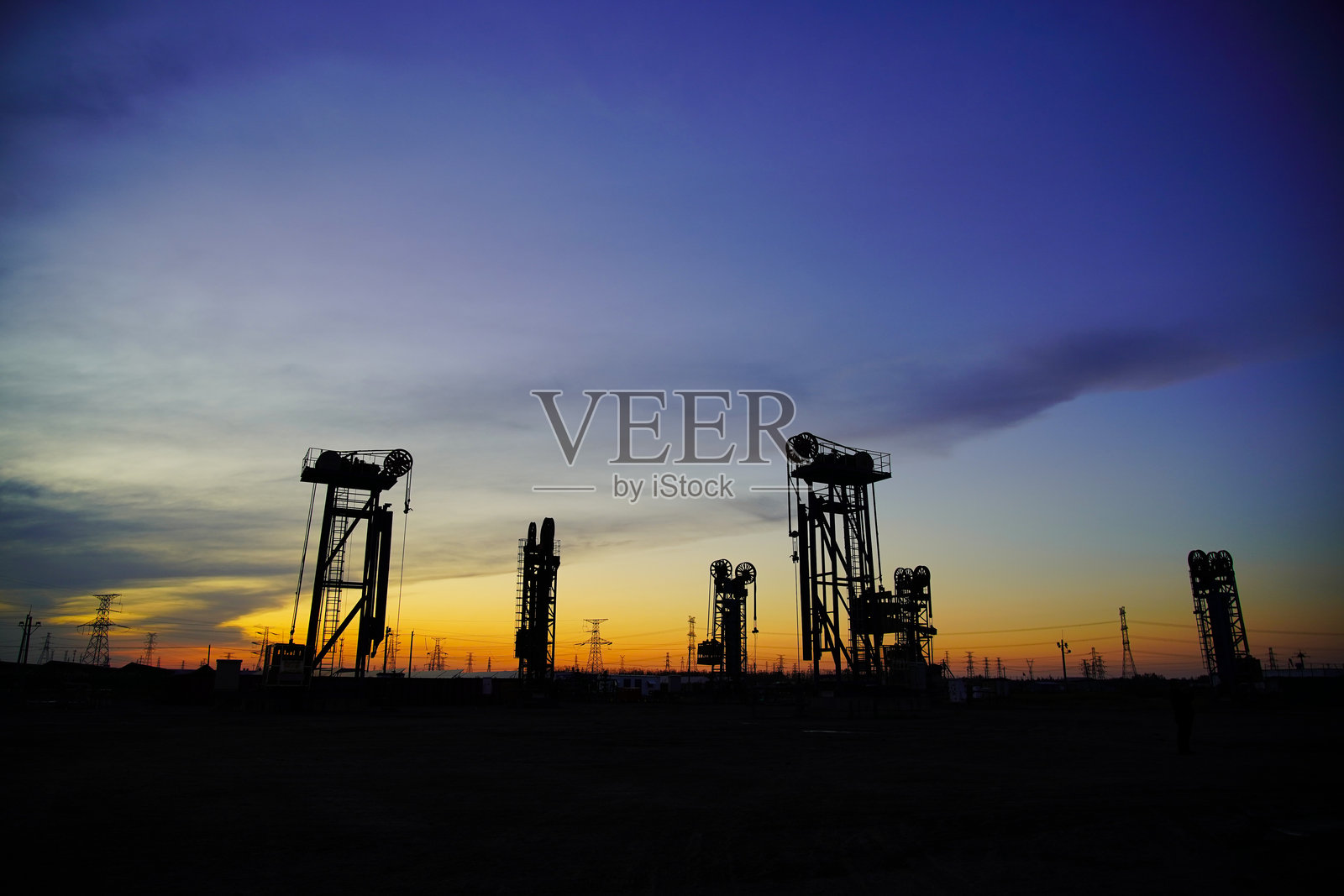 石油泵，工业设备。油田现场，石油泵正在运行。照片摄影图片