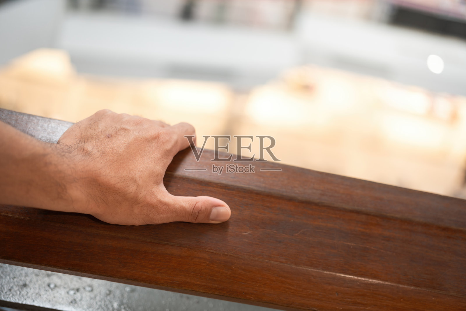 一只手放在木制栏杆上。照片摄影图片