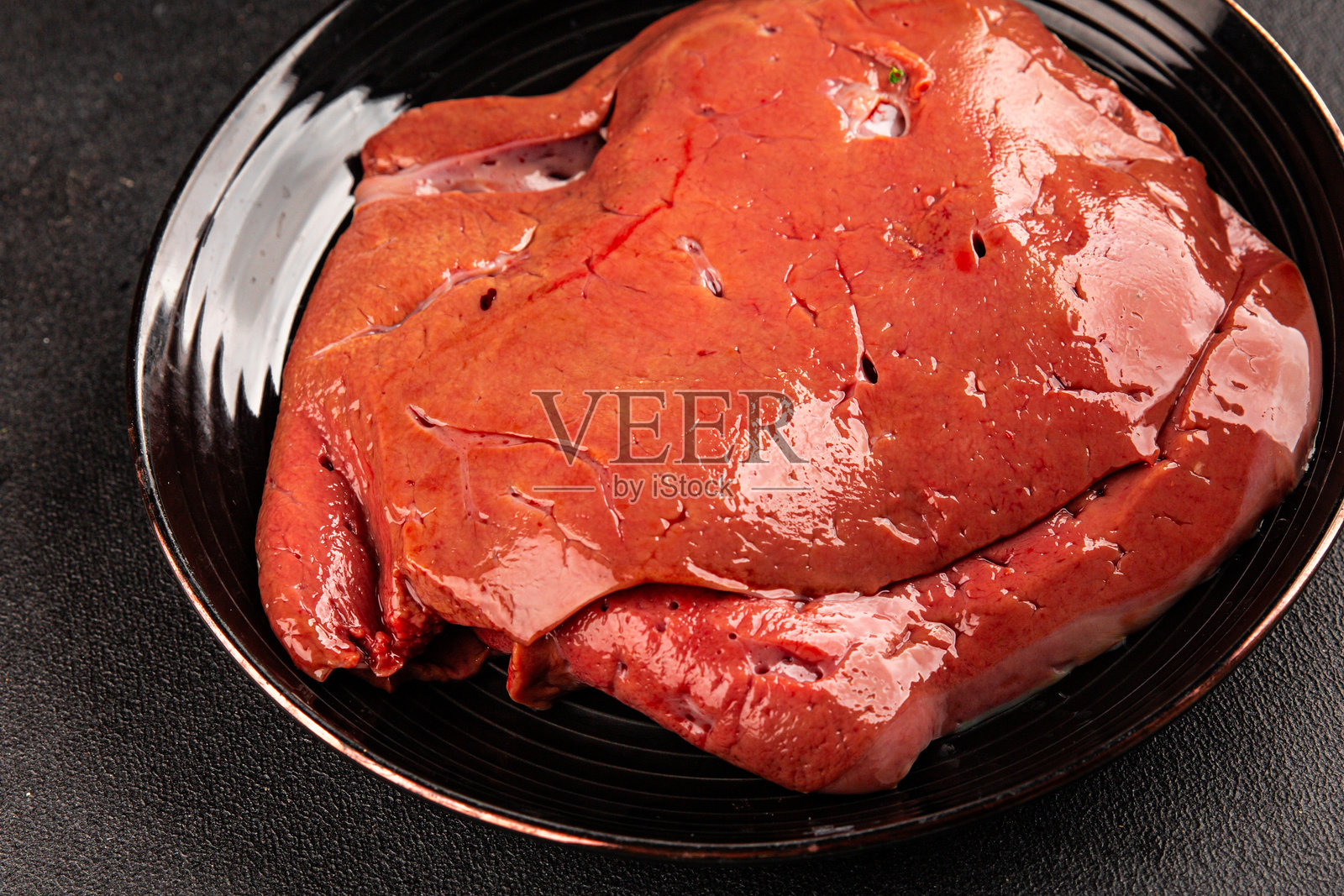 新鲜美味的烤小牛肉肝或猪肝内脏，作为开胃菜，摆放在乡村风格的餐桌上，俯视角度，留有复制空间，适合生酮或旧石器饮食照片摄影图片