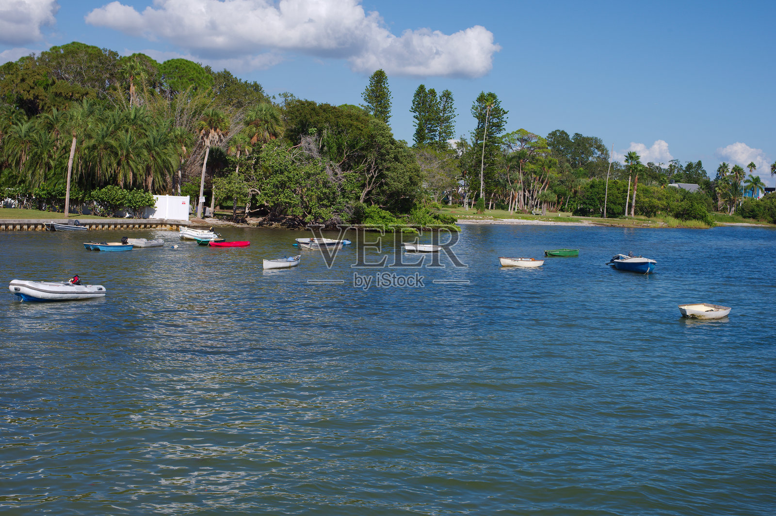 宁静的海滨风光，小船停泊在葱郁的热带海岸附近，天空湛蓝，位于佛罗里达州海湾港照片摄影图片