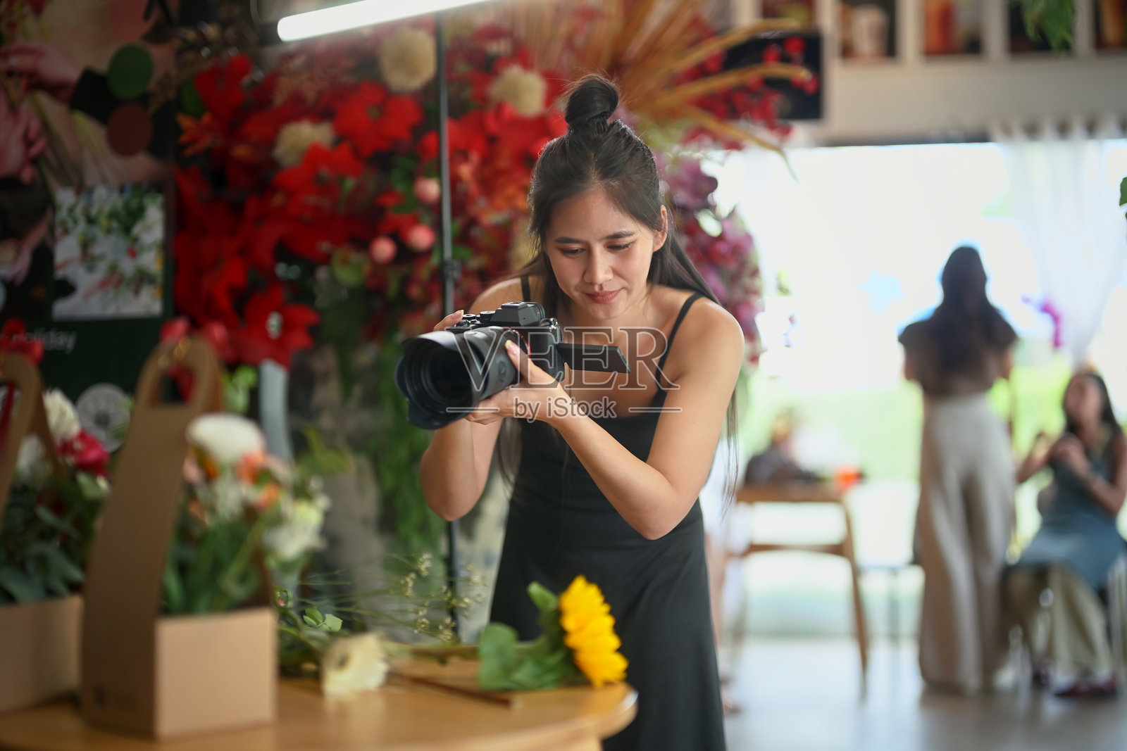 花店女店主在店里为她的花卉产品拍照照片摄影图片