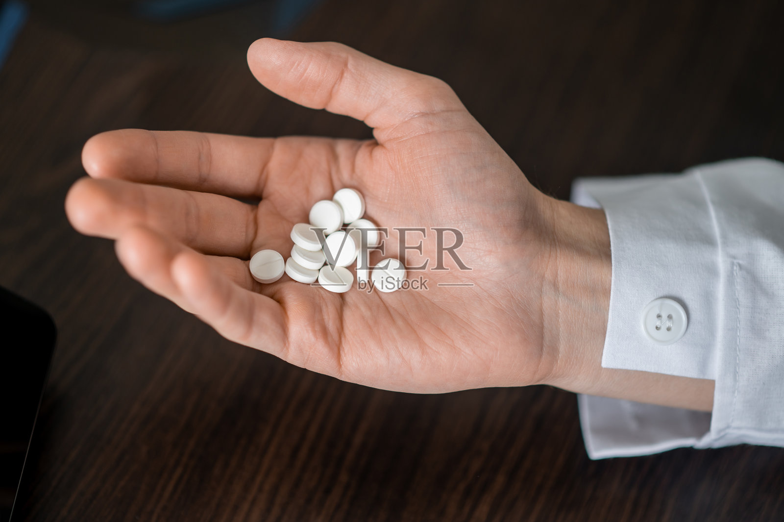 现代诊所里，医生手持药片的特写照片摄影图片