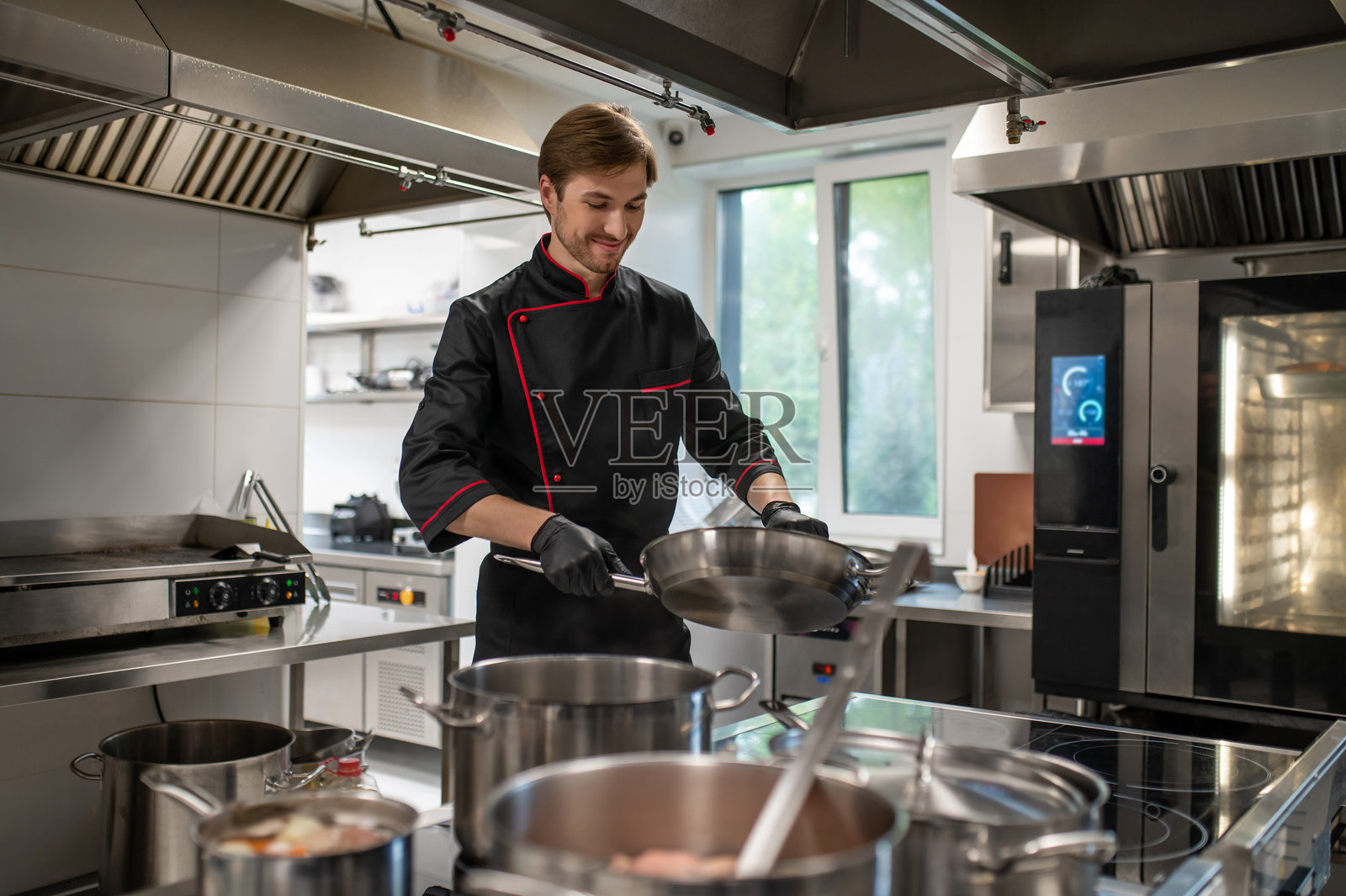 厨师在专业厨房里使用厨具照片摄影图片