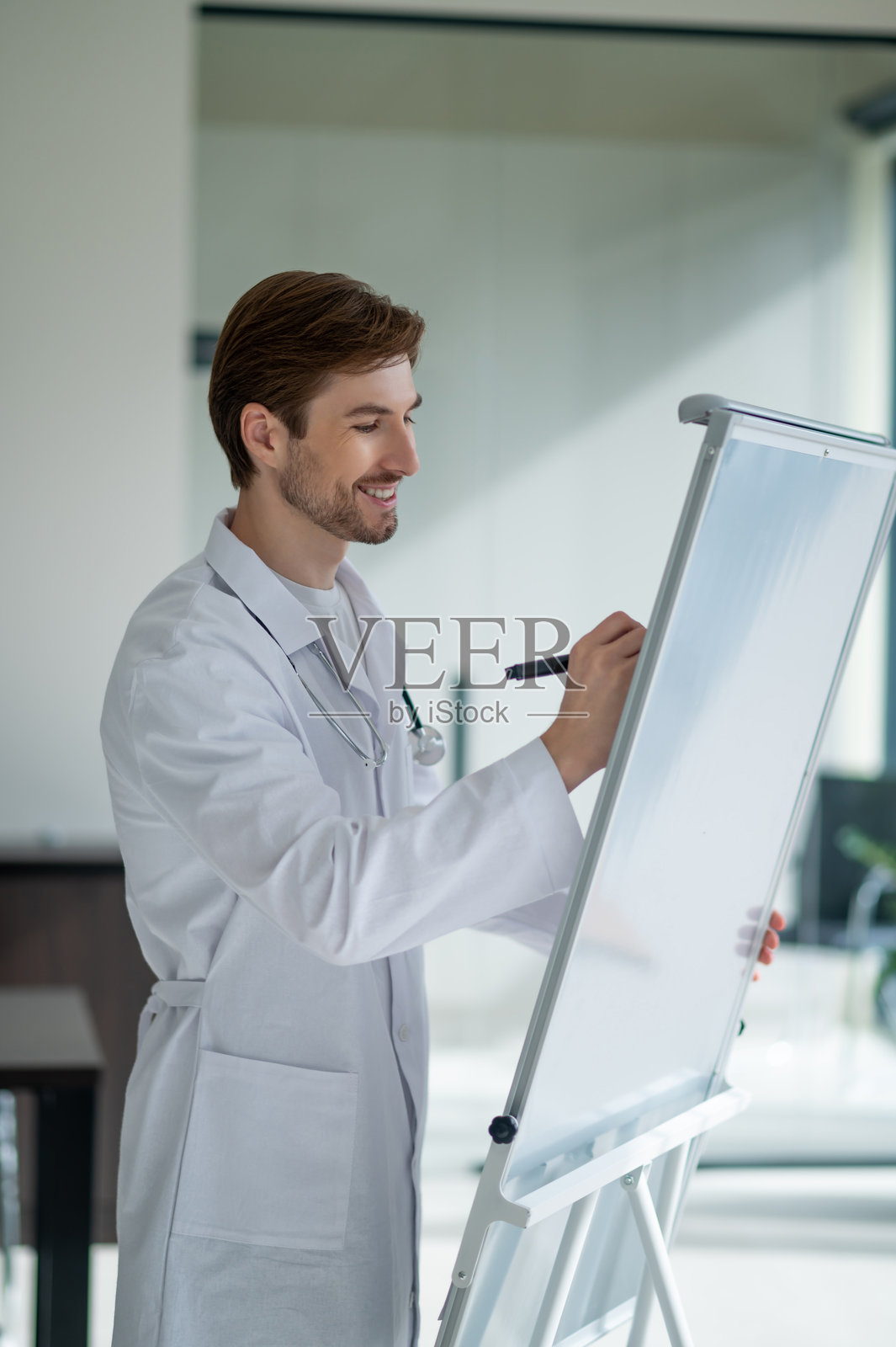 专业医务人员手持听诊器站在便携式翻页图前照片摄影图片