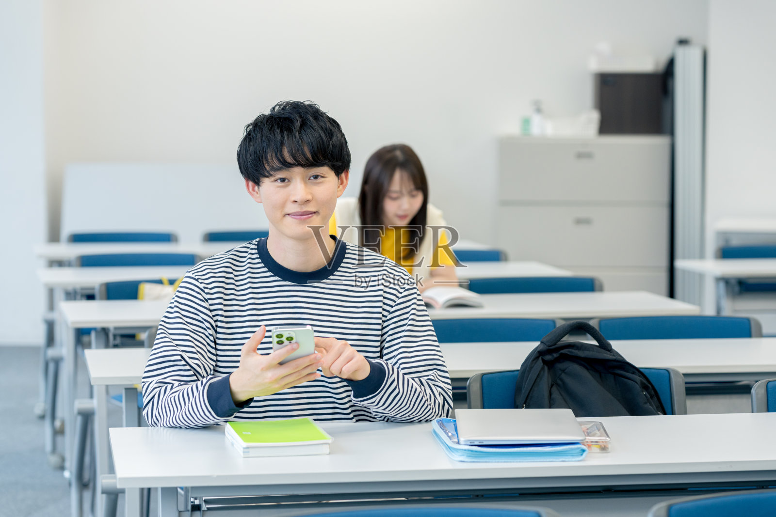 大学生在教室里看智能手机照片摄影图片