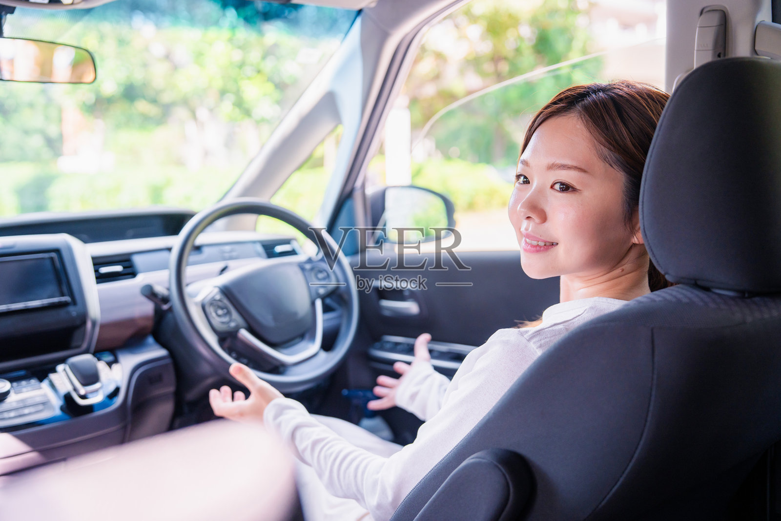 年轻女子在自动挡汽车里开车。照片摄影图片