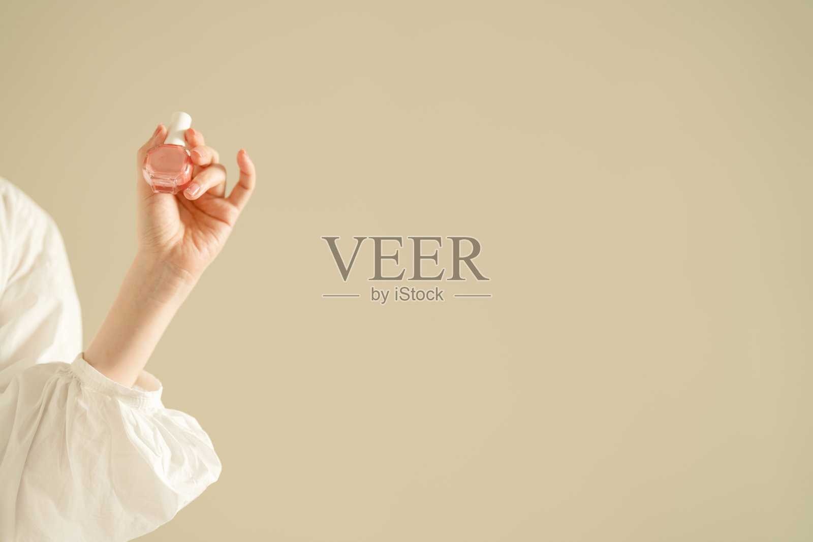 女士的手拿着粉色指甲油照片摄影图片