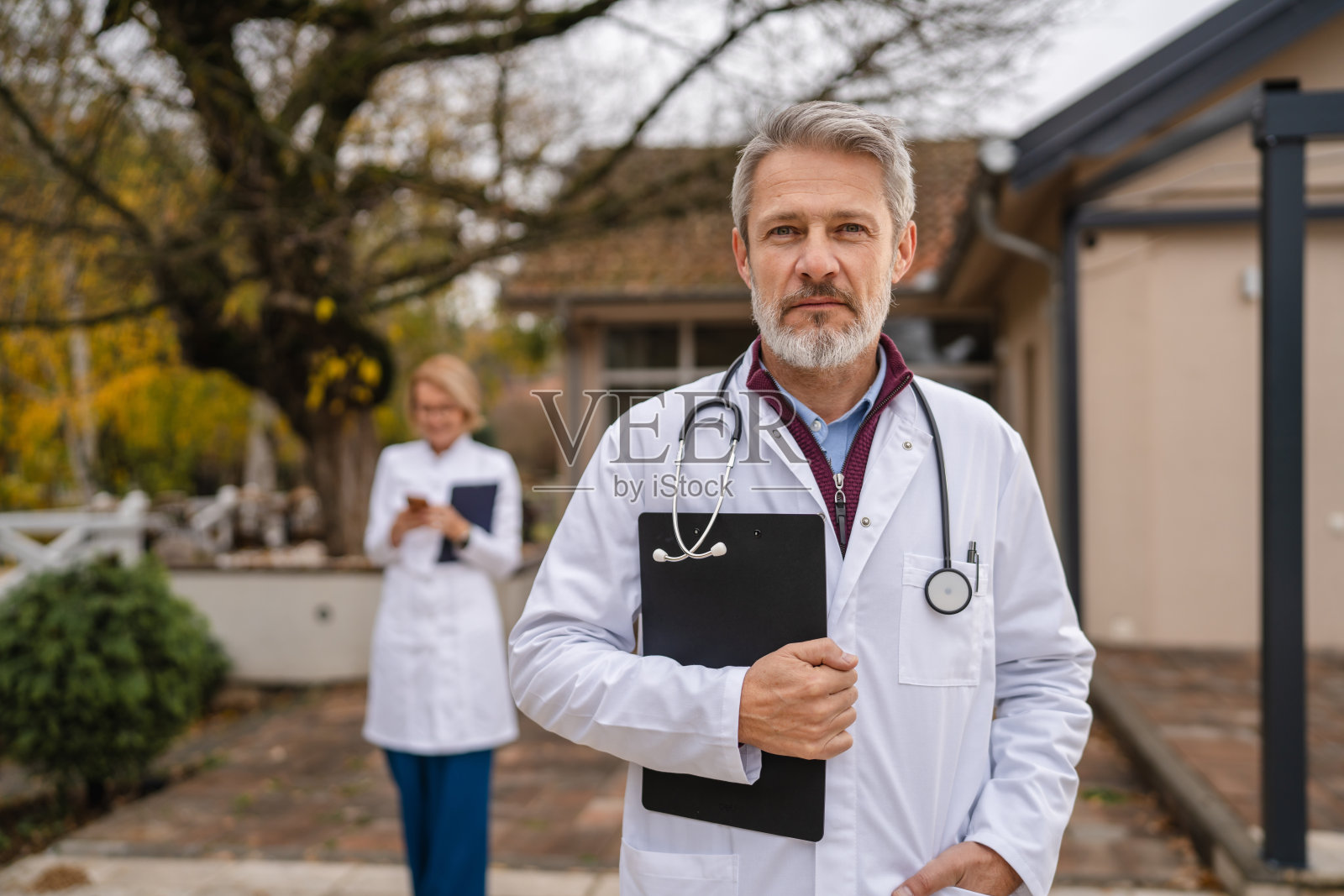 自信的成熟医生在户外拿着文件板照片摄影图片