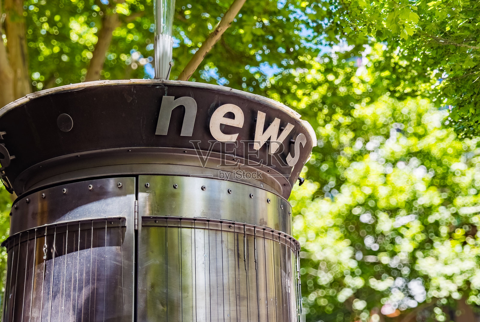 坐落于葱郁绿荫下的城市报刊亭照片摄影图片