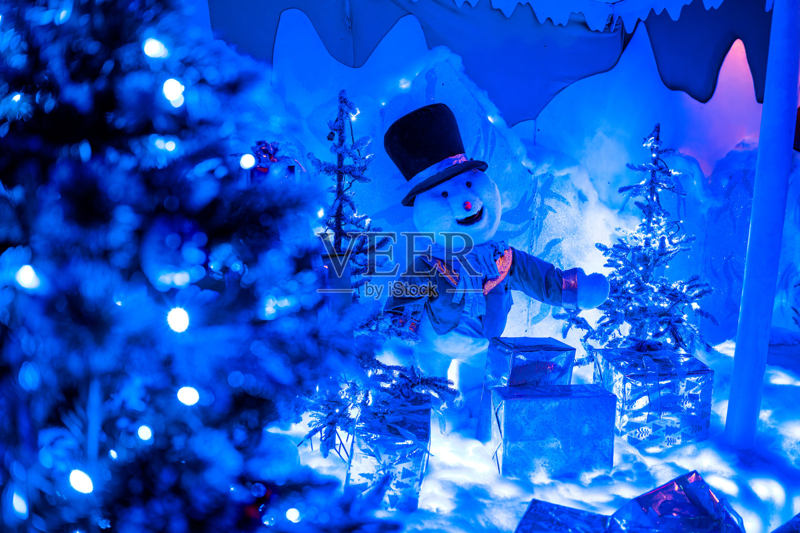 雪人弗罗斯蒂的冬日节日展示，配有蓝色灯光照片摄影图片