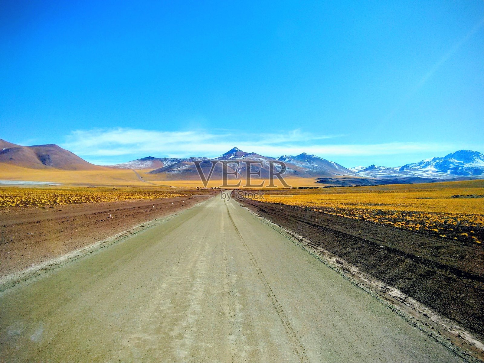南美安第斯山脉的火山干旱景观。穿过山谷的土路。照片摄影图片