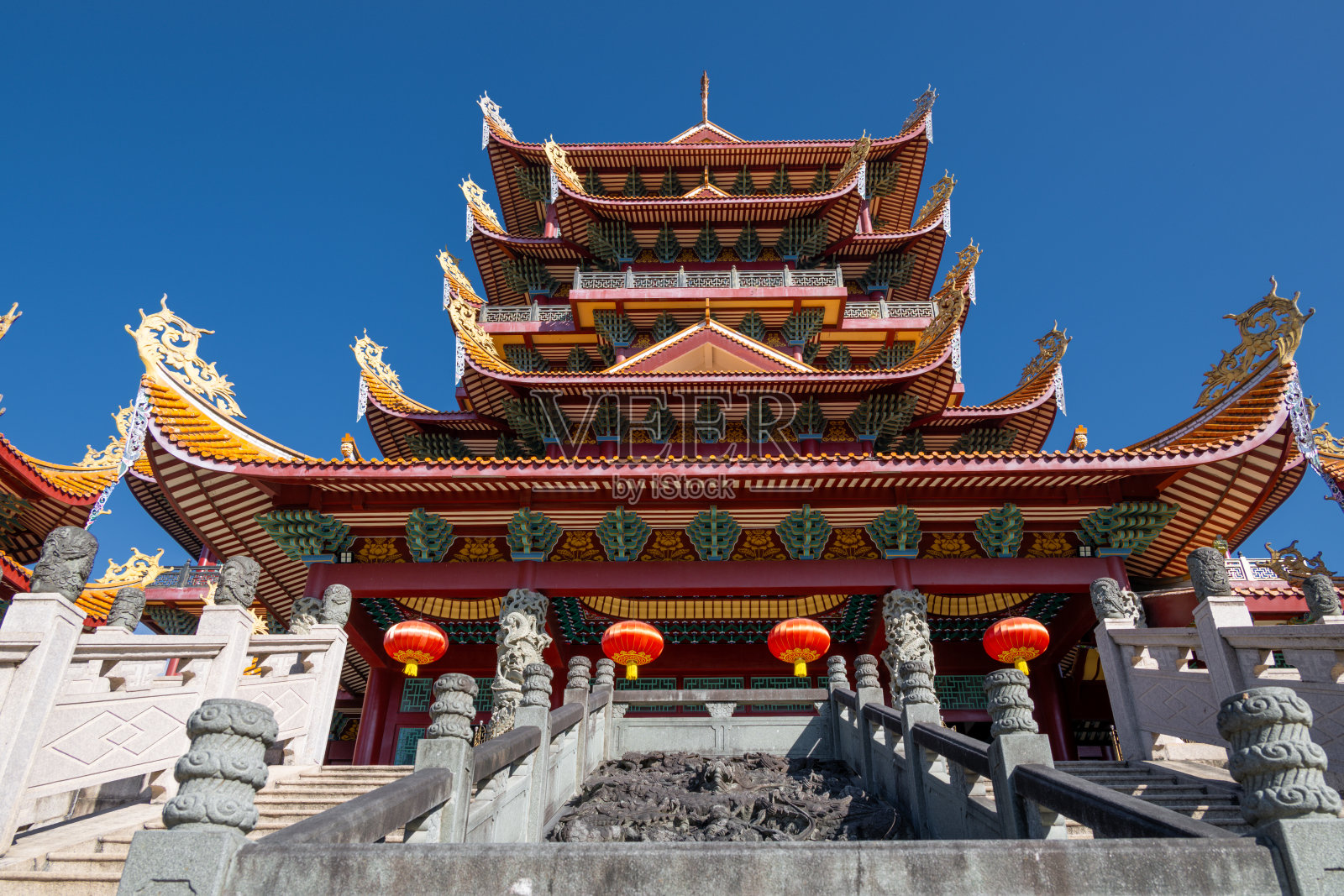 晴朗的蓝天下，宏伟的中国传统寺庙建筑，拥有华丽的屋顶和红灯笼照片摄影图片