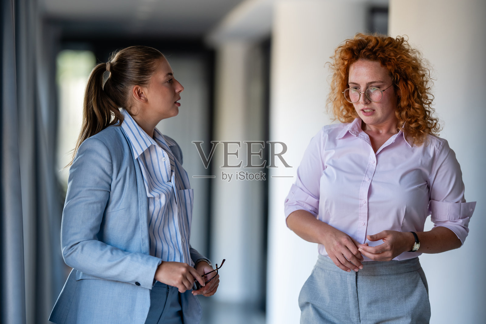 两位女商人正在办公室里进行严肃的谈话照片摄影图片