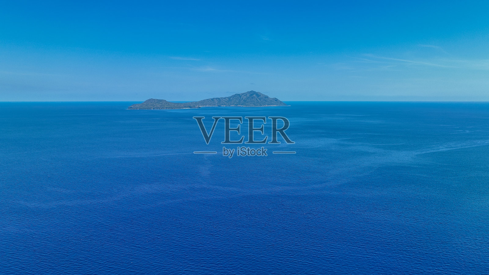 无垠的海洋环绕着恩德岛，碧绿的山峰在绿松石色的海浪之上显现，岛屿宁静地伸向地平线照片摄影图片