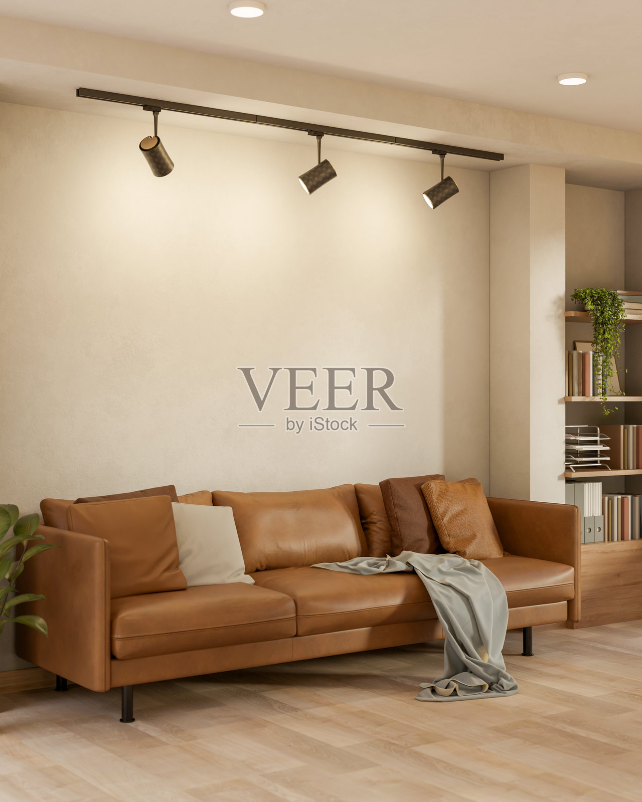 客厅里，一张棕色皮质沙发上铺着坐垫和毯子，在吊灯下方的木地板上。照片摄影图片