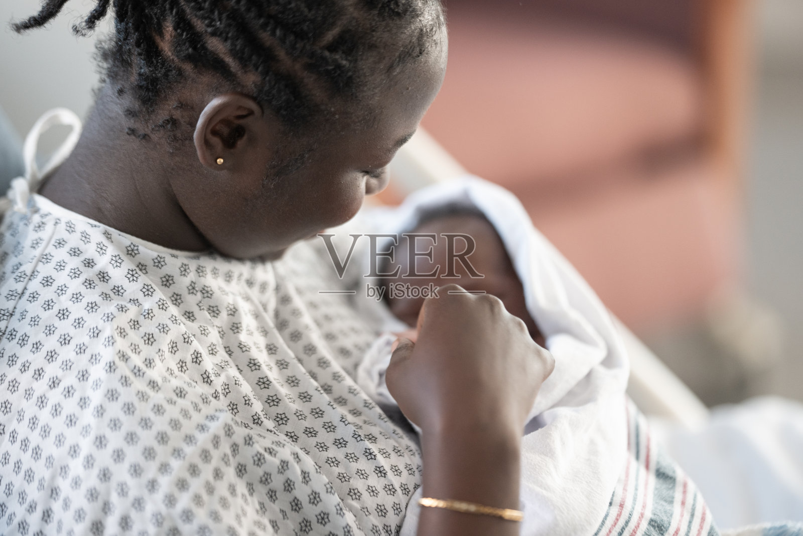 非裔美国母亲在医院病房中抱着刚出生的婴儿照片摄影图片