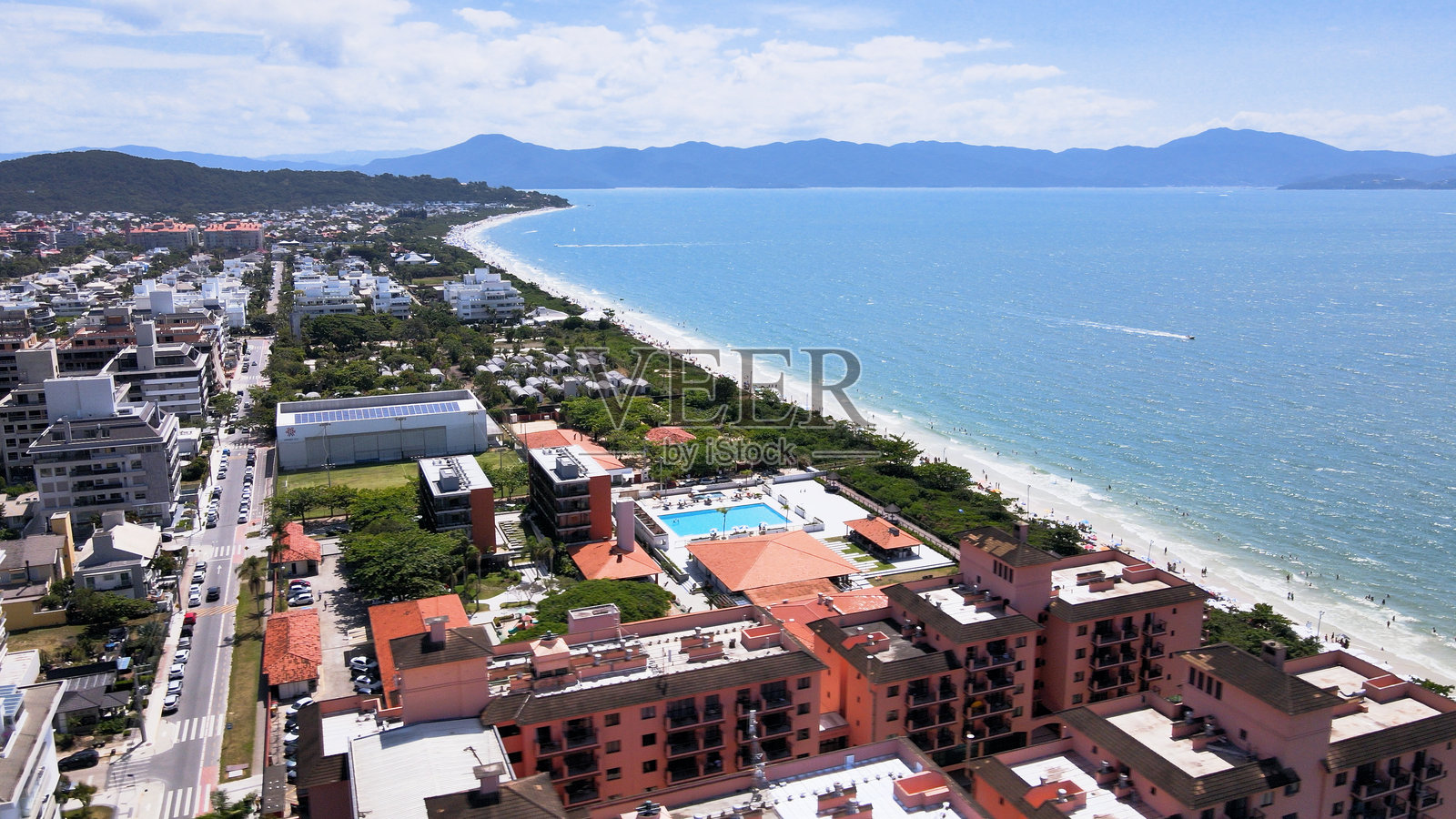 全景航拍视角下的弗洛里亚诺波利斯儒雷尔国际海滩，展示了豪华住宅、海滩俱乐部、海滨高端住宅以及游客众多、人群拥挤的奢华旅游海滩沙滩。照片摄影图片