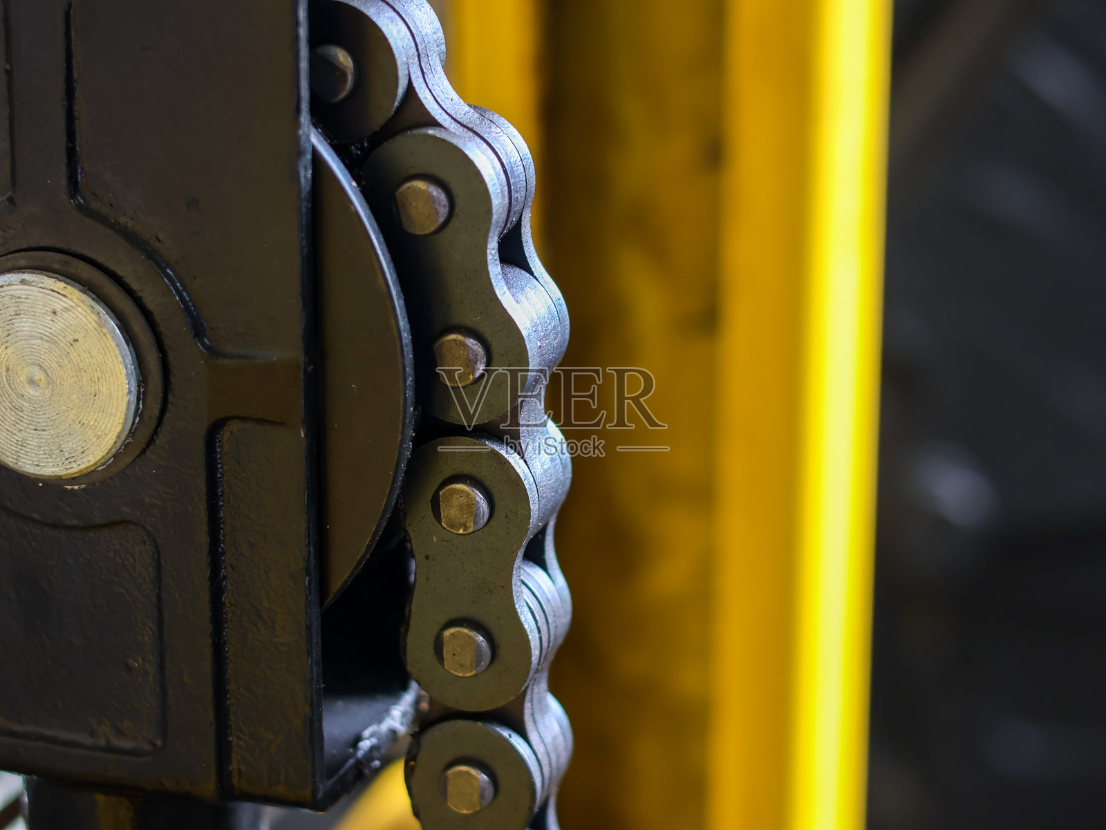 重型滚子链在黑色工业起重机装置中啮合的特写照片摄影图片