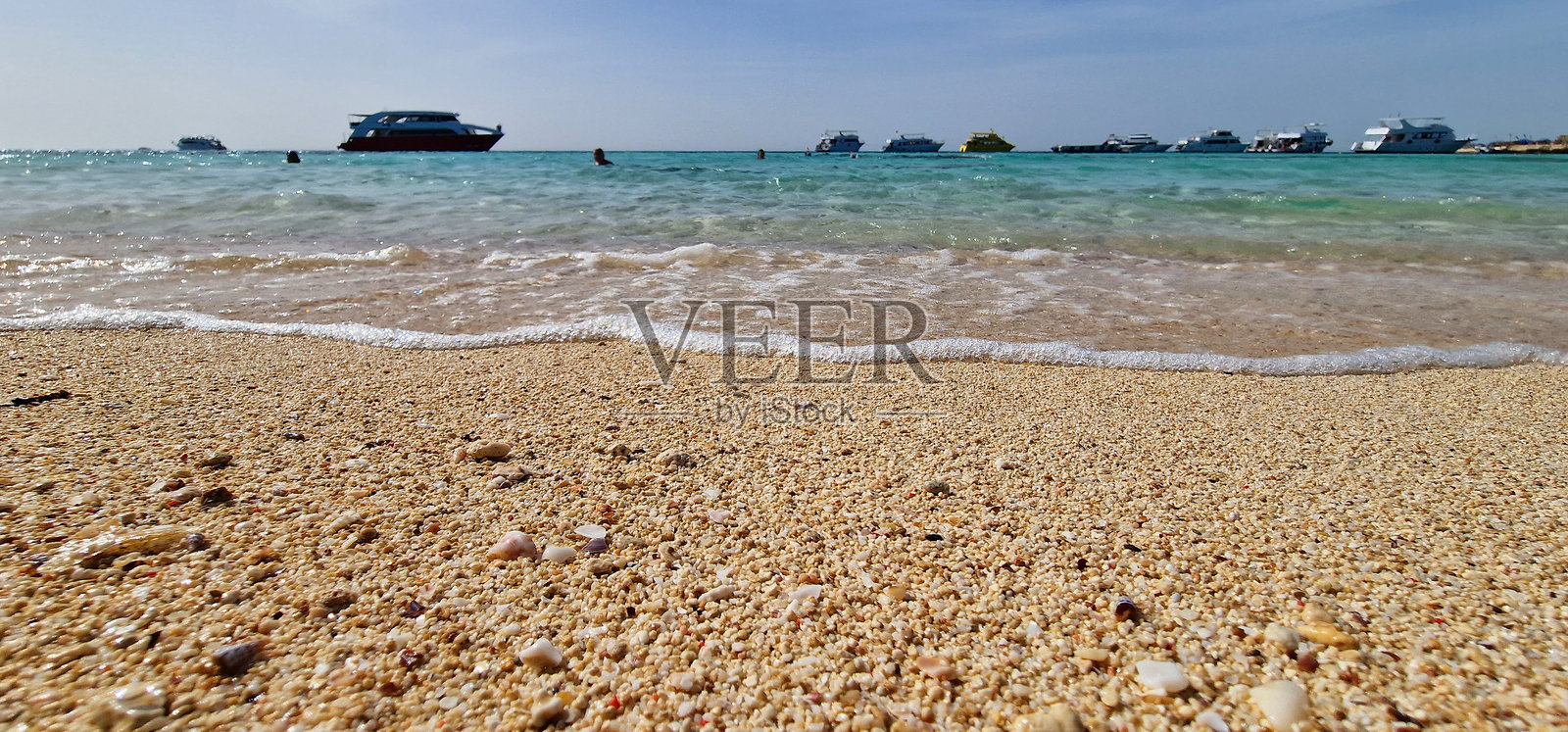 埃及红海，有船的贝壳沙滩和绿松石般的海水照片摄影图片