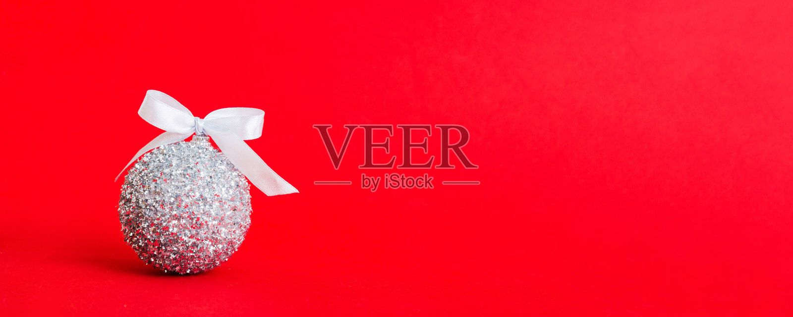 彩色背景上的圣诞装饰球。带有丝带蝴蝶结的装饰挂饰，可供复制。照片摄影图片