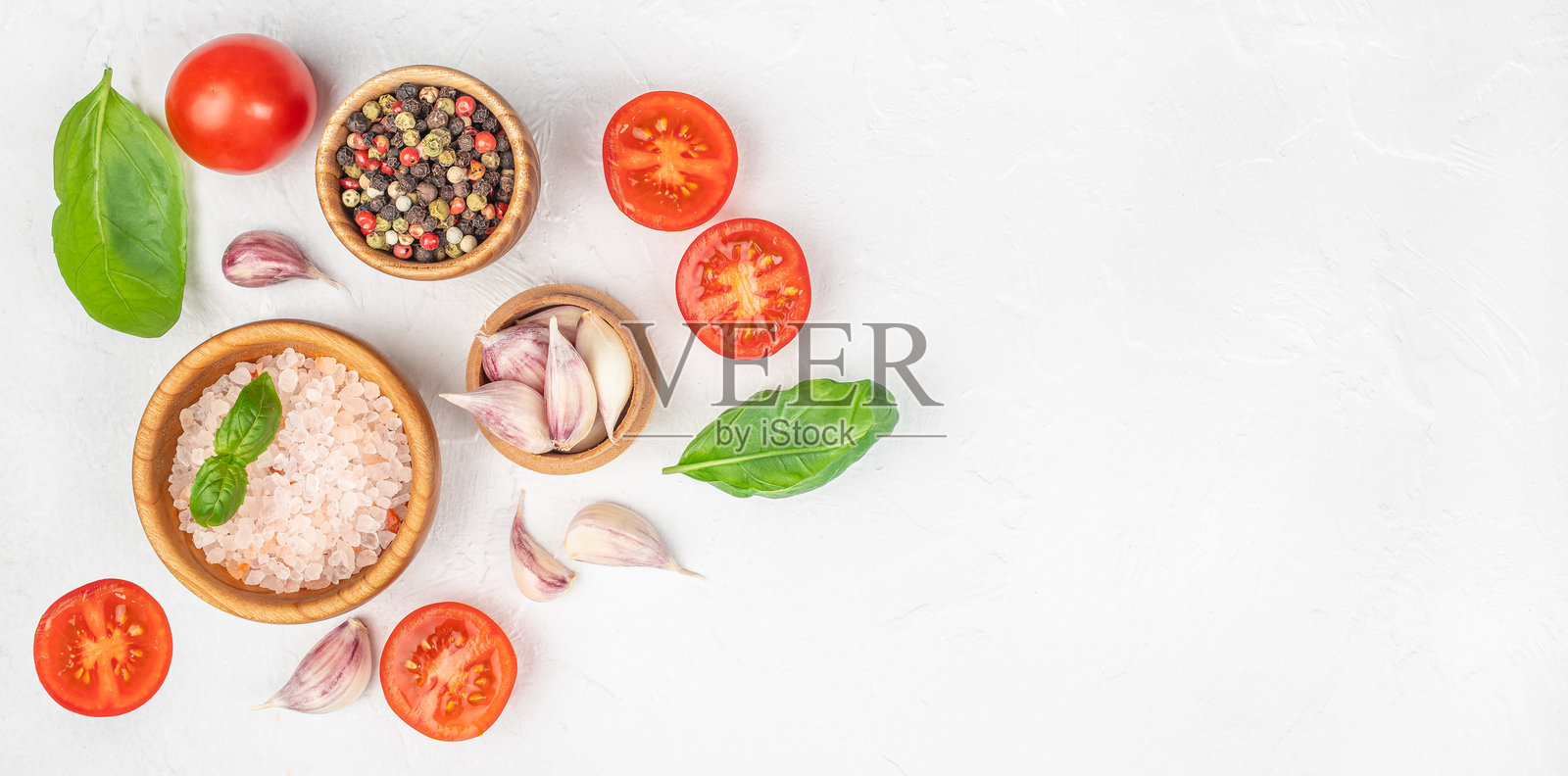 白色纹理背景上新鲜的烹饪食材，包含番茄、大蒜、罗勒和香料，并留有复制空间照片摄影图片