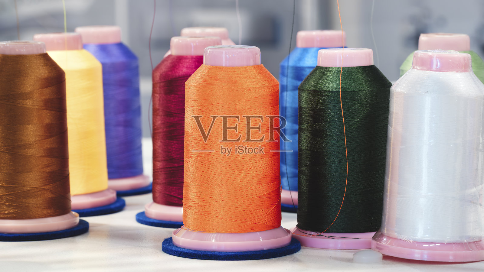 带有彩色线工业刺绣机在织物上，工业概念背景照片摄影图片