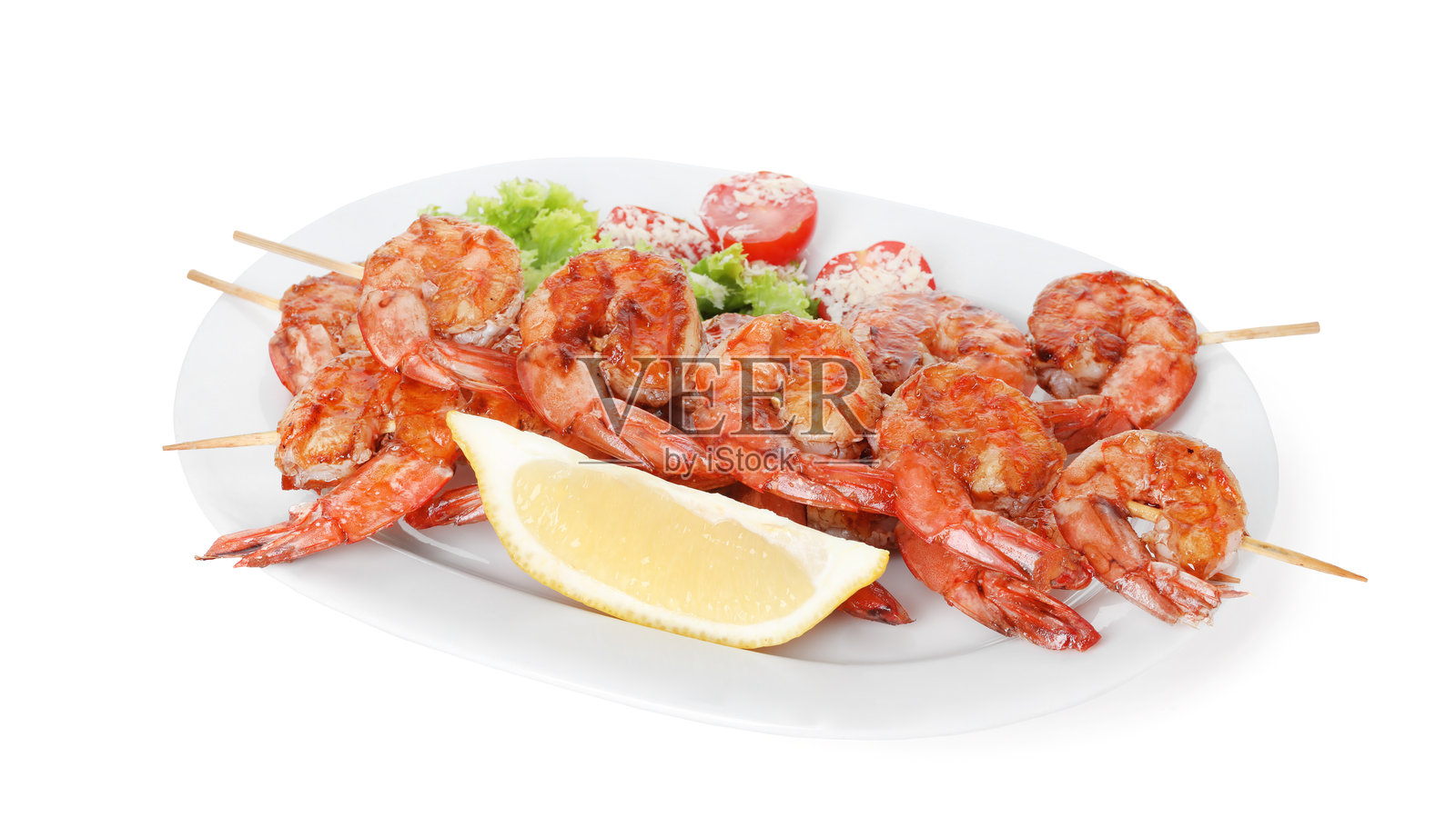 烤虾串配沙拉和柠檬片，白色背景，美味海鲜料理照片摄影图片