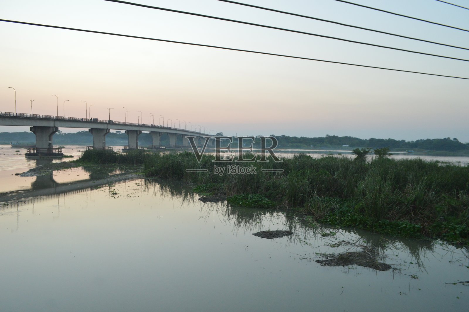 日落时分的桥梁和倒映在水中的路灯剪影照片摄影图片
