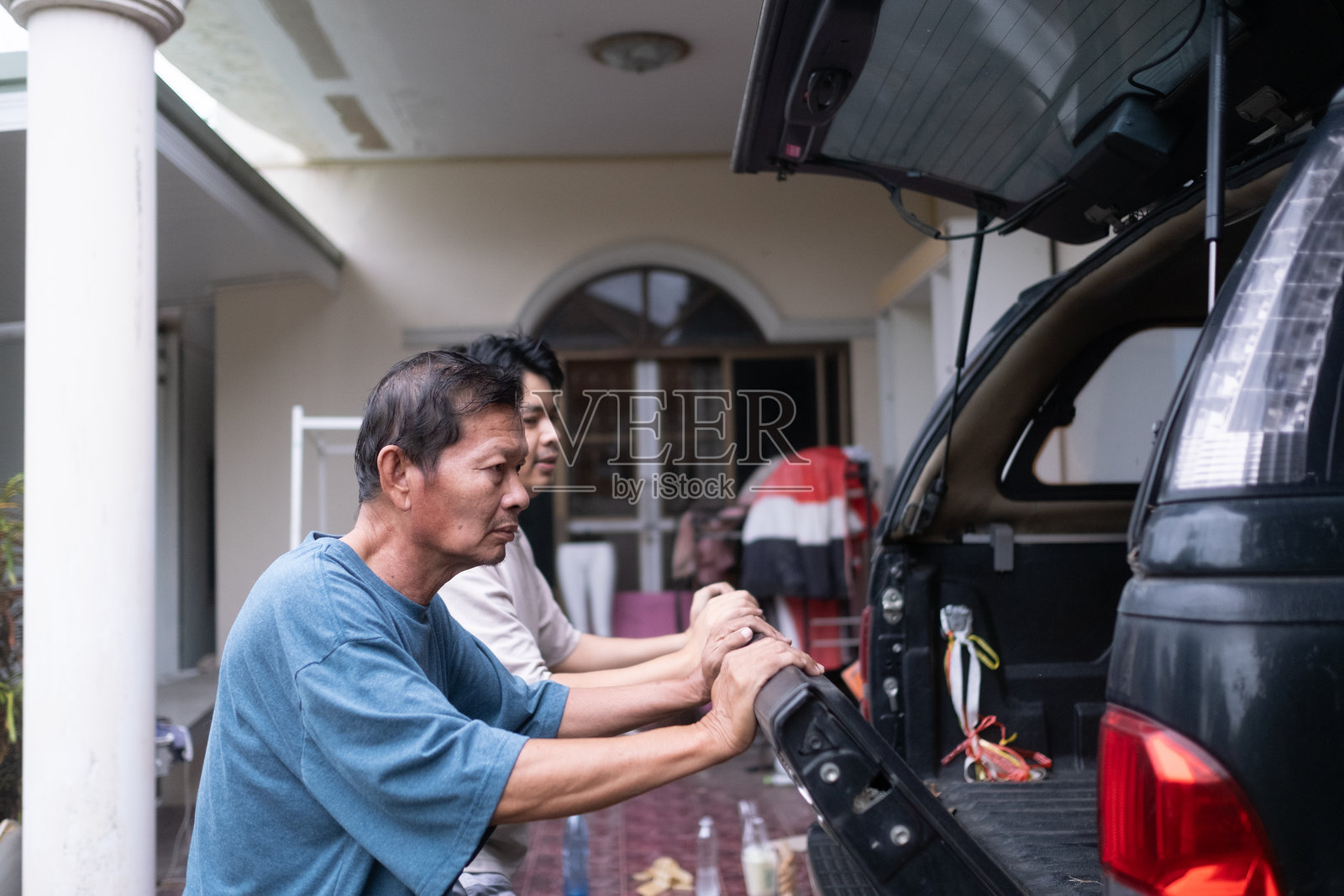 两名男子正站在一辆黑色卡车的后厢照片摄影图片