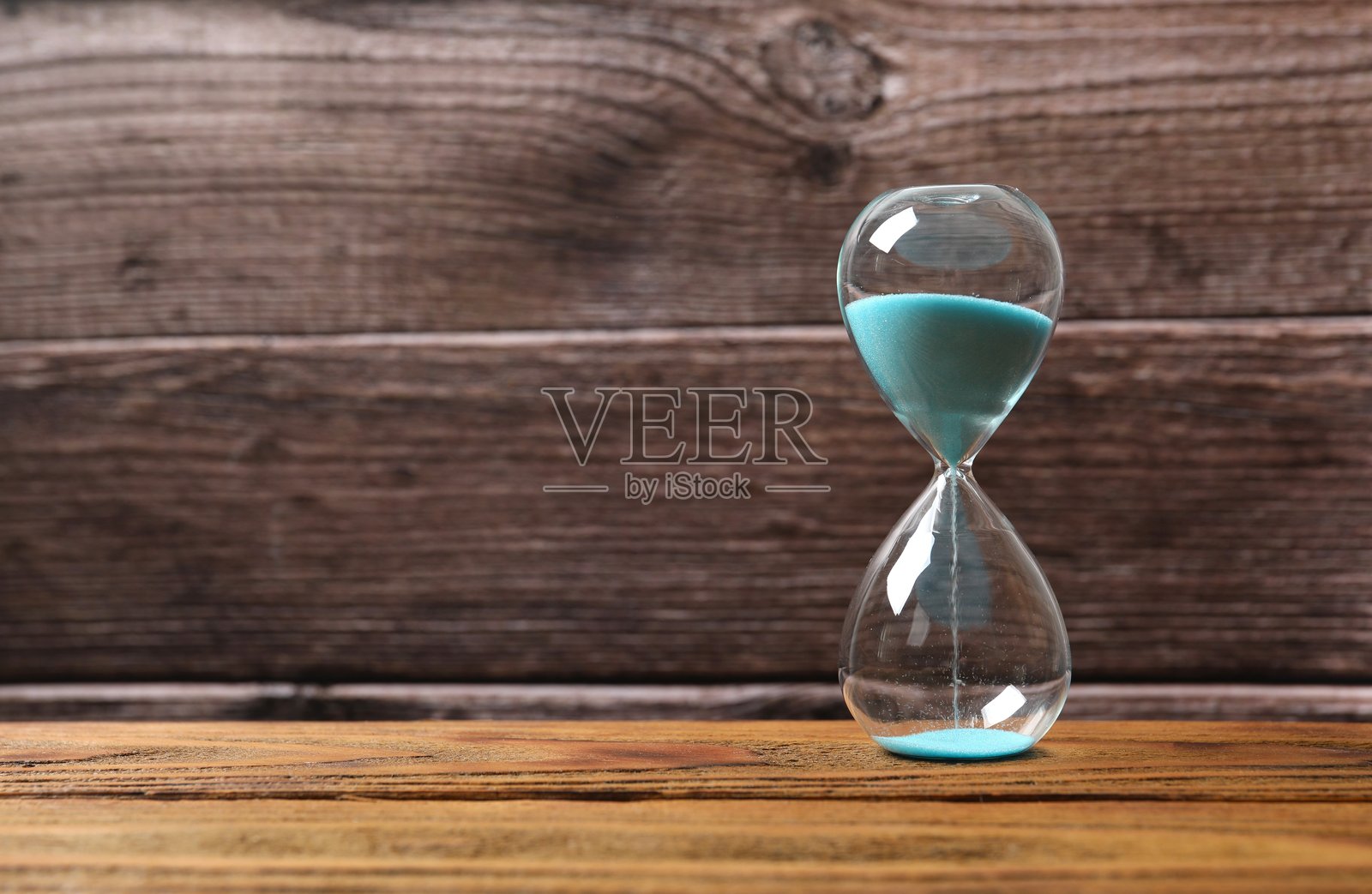 木质背景上的现代沙漏。沙漏时间概念，用于商业截止日期、紧迫性和时间结果照片摄影图片