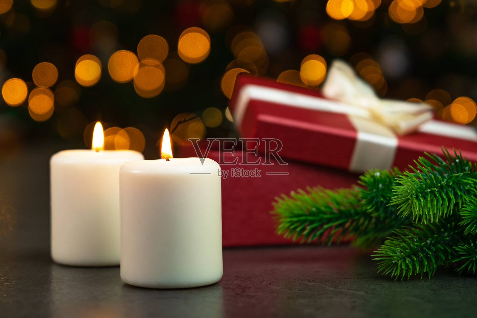 圣诞树旁的点燃的蜡烛和装有圣诞礼物的盒子。圣诞新年照片摄影图片