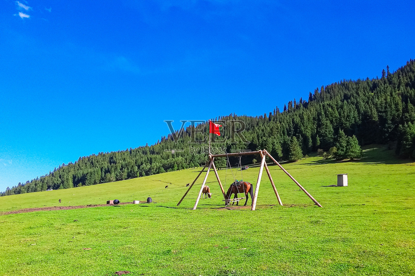 美丽的绿色山谷，有绿色的田野、春天的绿草、起伏的山丘和远处的山脉，背景是风景如画、色彩斑斓的云彩落日。照片摄影图片