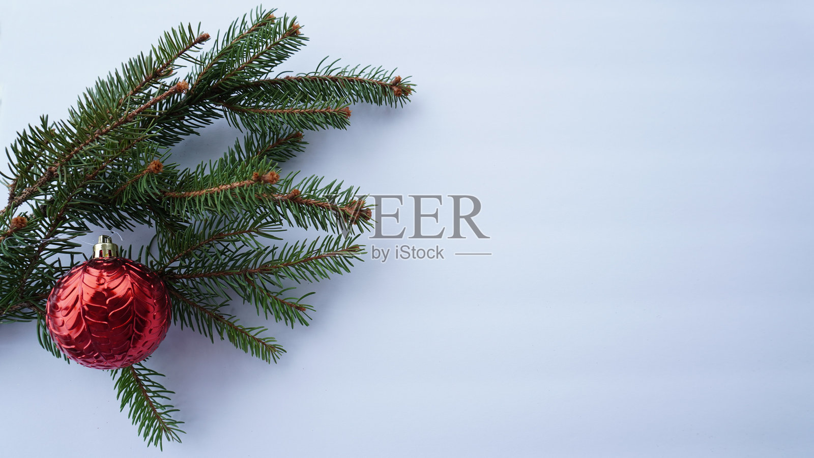 圣诞节。白底上的红色圣诞树玩具和冷杉枝照片摄影图片