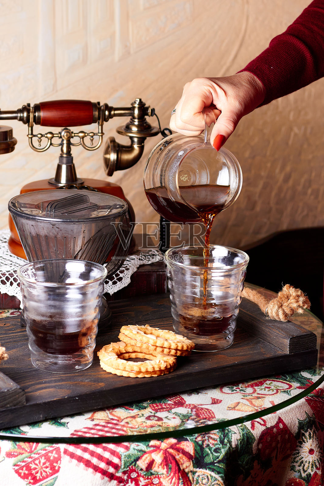 女咖啡师的手正将用虹吸壶冲泡的热咖啡倒入杯中照片摄影图片